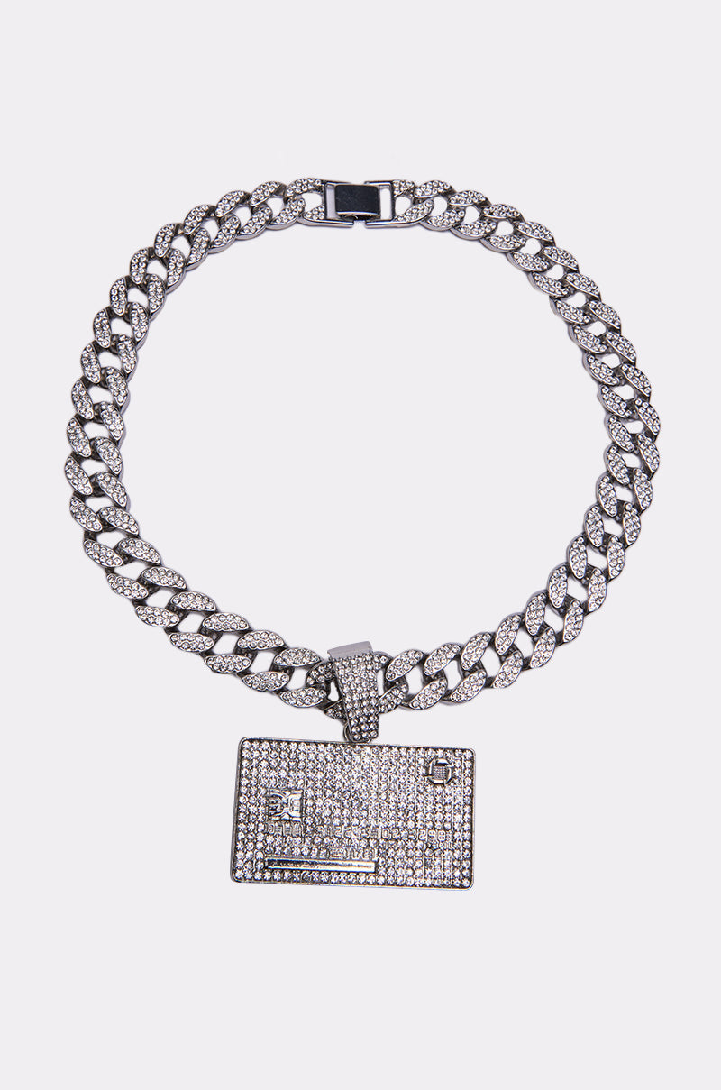 The CHARGE IT NECKLACE is a chunky Cuban chain necklace with rhinestones and a rectangular, diamond-encrusted credit card pendant.