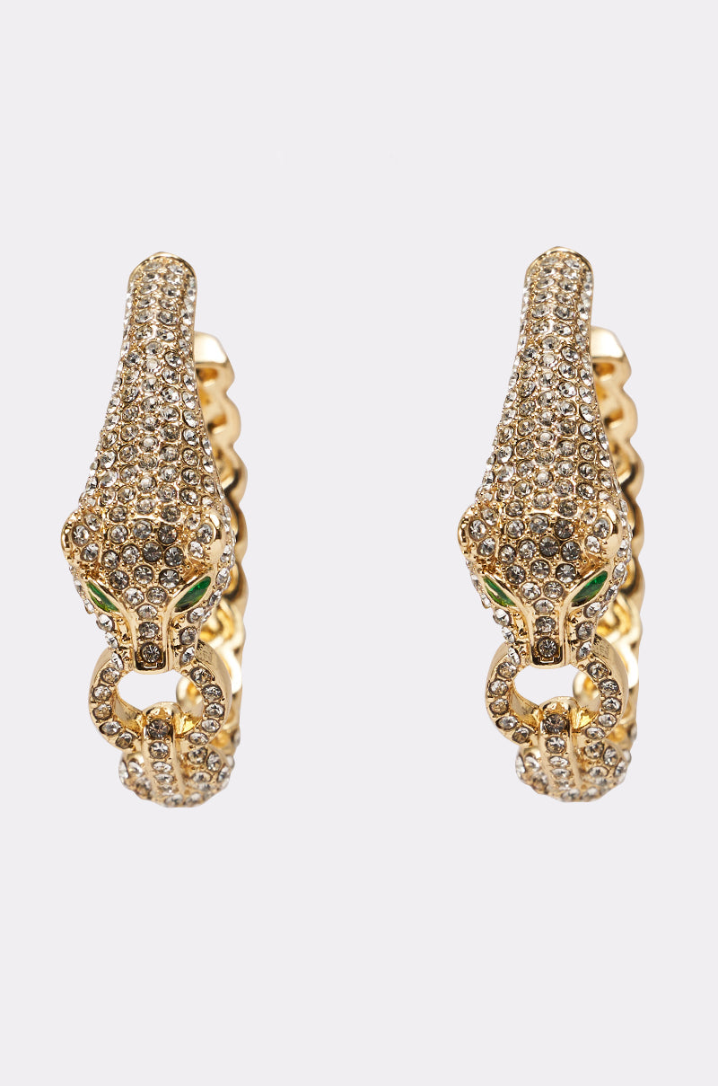 The LUXE JAG EARRING features gold hoop earrings shaped like jaguar heads with rhinestone accents, green gemstone eyes, and each holds a ring in its mouth. 2