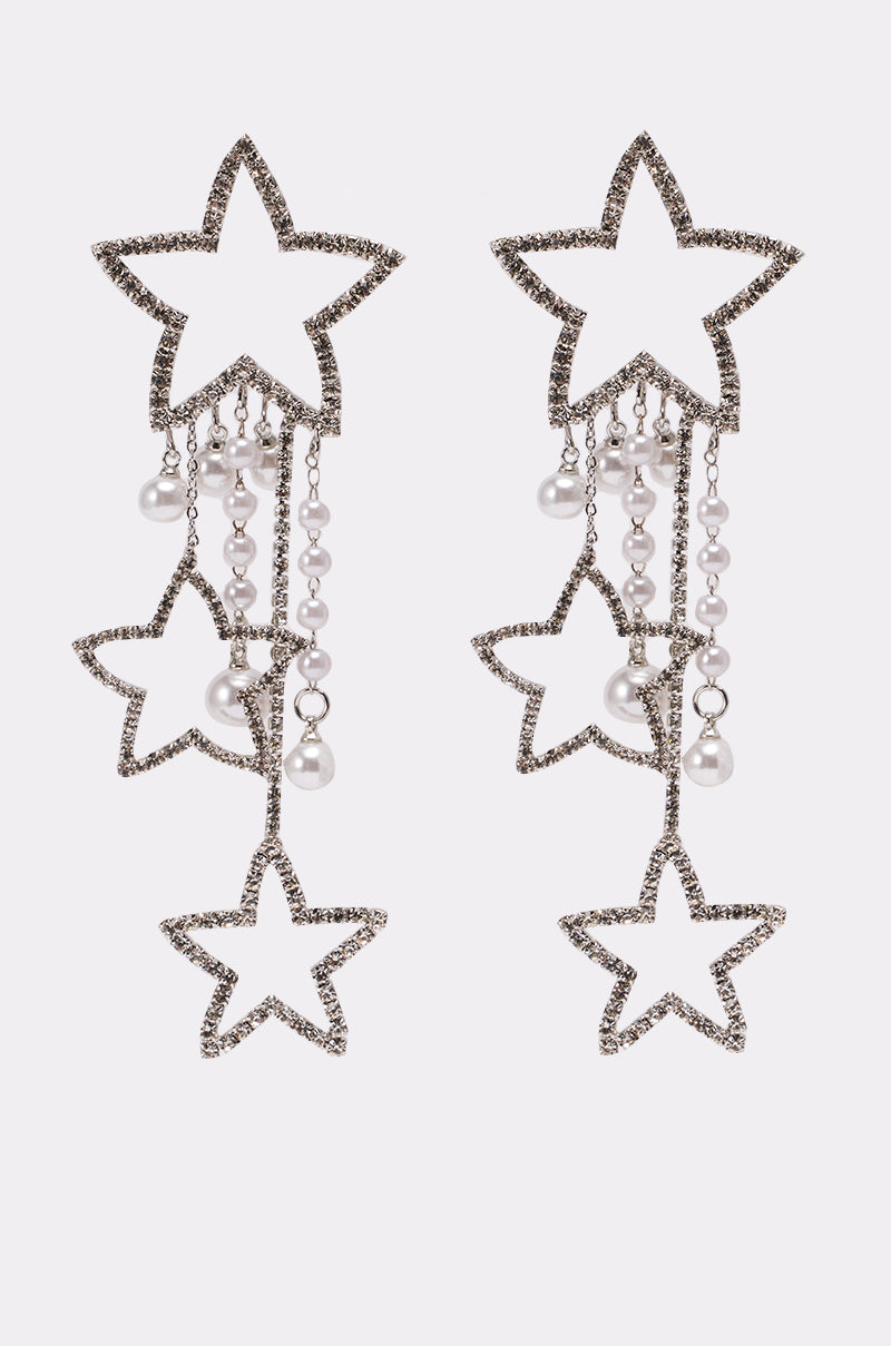 The LIGHT IT UP EARRING showcases rhinestone star studs with dangling pearls and multiple chains, creating a bold statement piece, displayed against a plain white background. 1