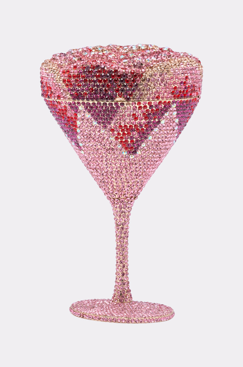The TAKE A SIP BLING PURSE is a martini glass-shaped clutch adorned with sparkling pink and red rhinestones in intricate patterns, creating a luxurious statement accessory that pops against a plain, light gray background. 4