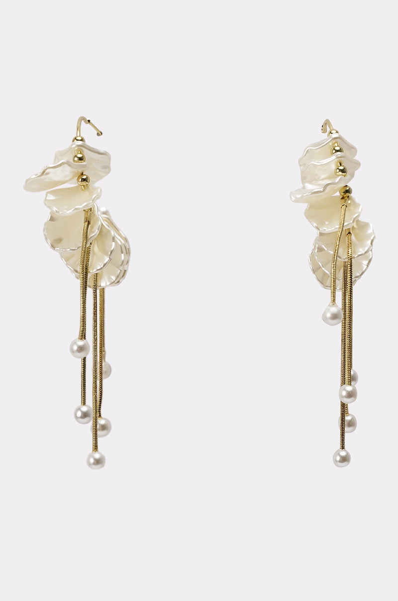 The KYLA EARRING features elegant, layered wavy gold-toned and pearlescent elements with long gold chains and pearl-like beads at the ends, displayed against a plain white background. 2