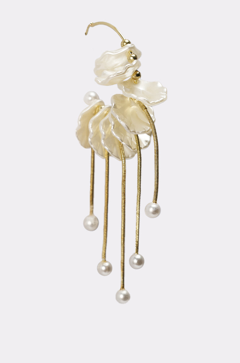 The KYLA EARRING is a gold statement piece featuring layered white petal-like elements and five dangling gold strands with round white pearls—ideal as wedding jewelry, shown against a light gray background. 3