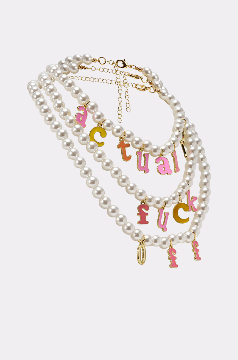 The I SAID WHAT I SAID NECKLACE features three-layered faux pearl strands, gold clasps, and pink and yellow enamel letter charms spelling “actual fuck,” plus bonus hanging charms and a gold extension chain for bold streetwear style. 2