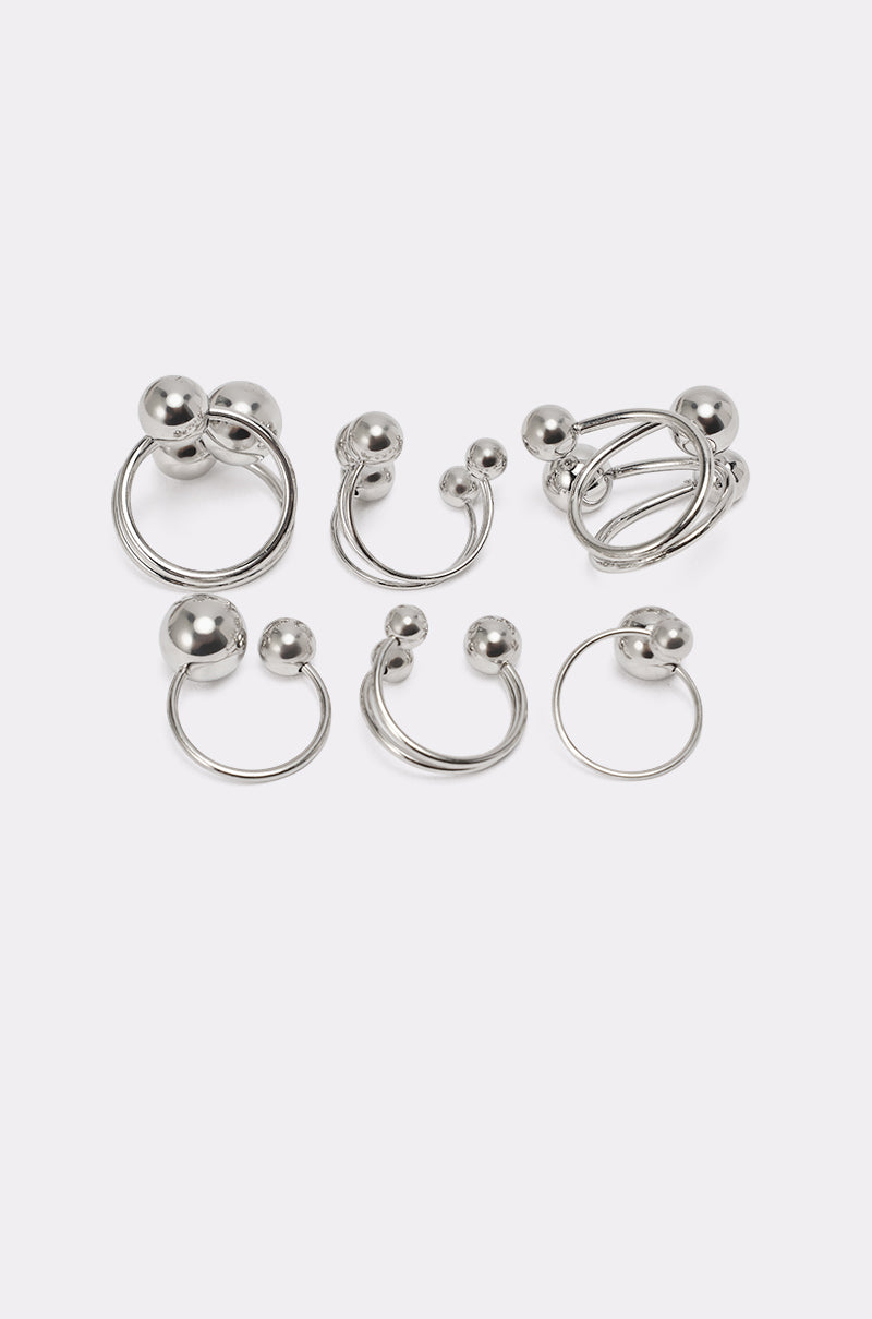 The MOD GAL RING SET features six silver-tone earrings in hoop and horseshoe shapes with ball ends, displayed on a plain white background. 4