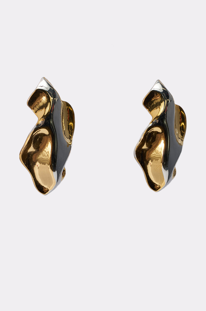 The MIXED FEELINGS EARRING features an abstract, sculptural design crafted from mixed metals, with shiny gold and black enamel accents, shown against a plain white background. 2
