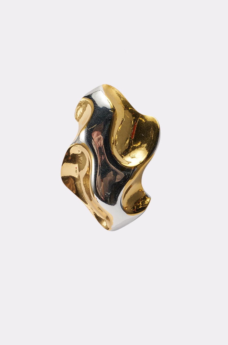 The MIXED FEELINGS EARRING features smooth, wavy surfaces in polished gold and silver tones, creating an abstract, modern statement design against a plain white background. 3