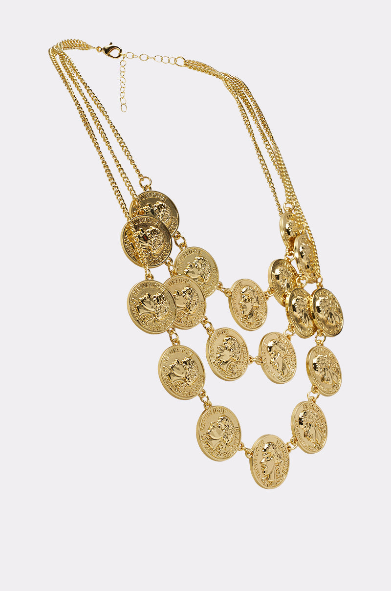 The IN MY BAG NECKLACE features vintage-inspired gold-tone layered chains with large, round embossed coin pendants in three rows. An adjustable clasp and ornate detailing on each coin add a charming touch. 2