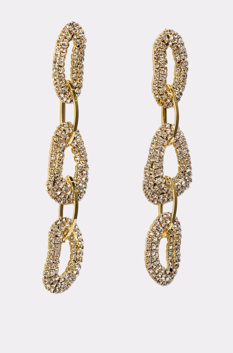 The WILD ONE EARRING features gold-tone statement drops with three interlocking oval links encrusted in sparkling rhinestones, adding glamour and elegance. Shown on a plain white background. 4