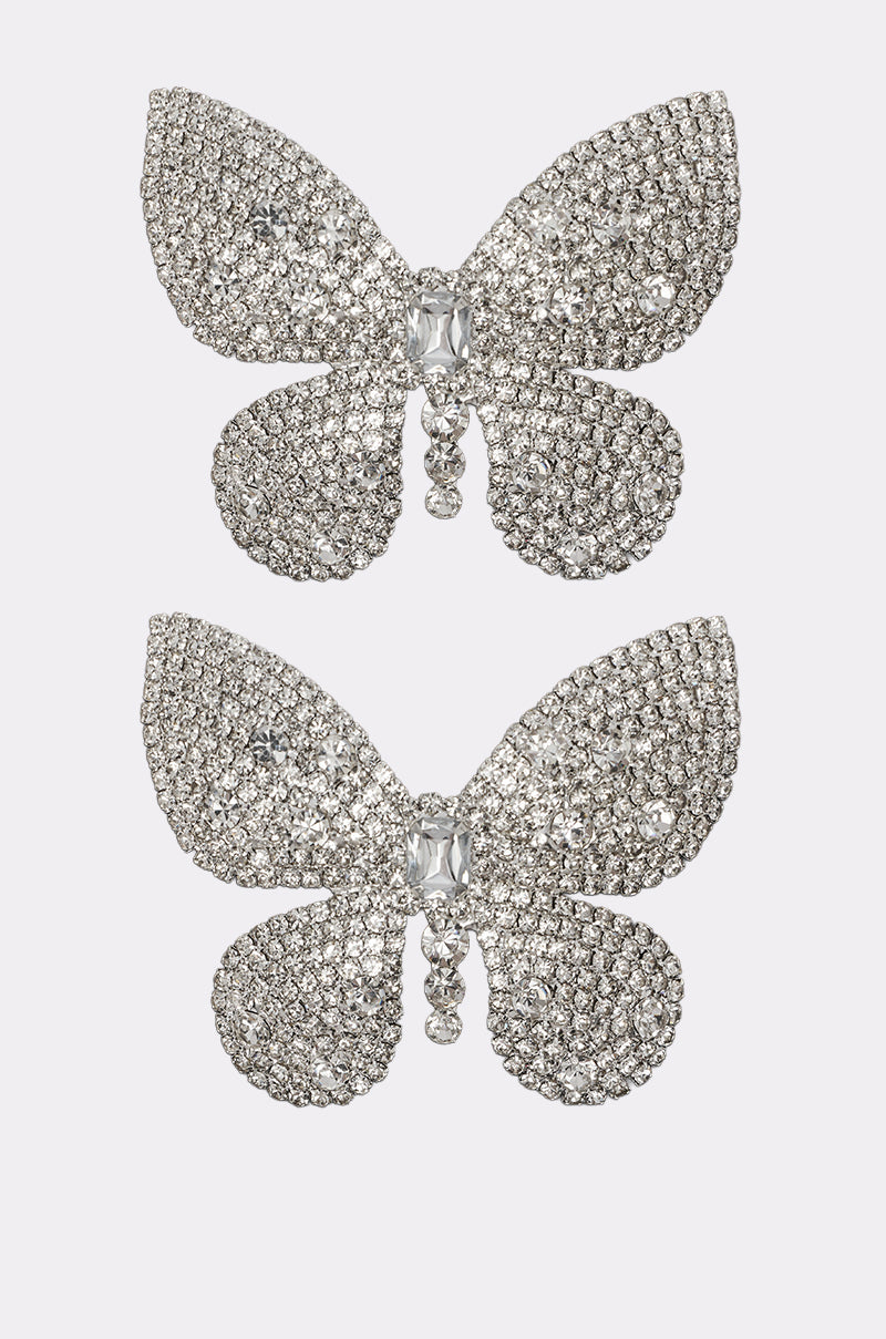 The FLY AWAY HAIR CLIP SET features two butterfly-shaped clips encrusted with clear rhinestones, displayed one above the other against a plain light background. 3
