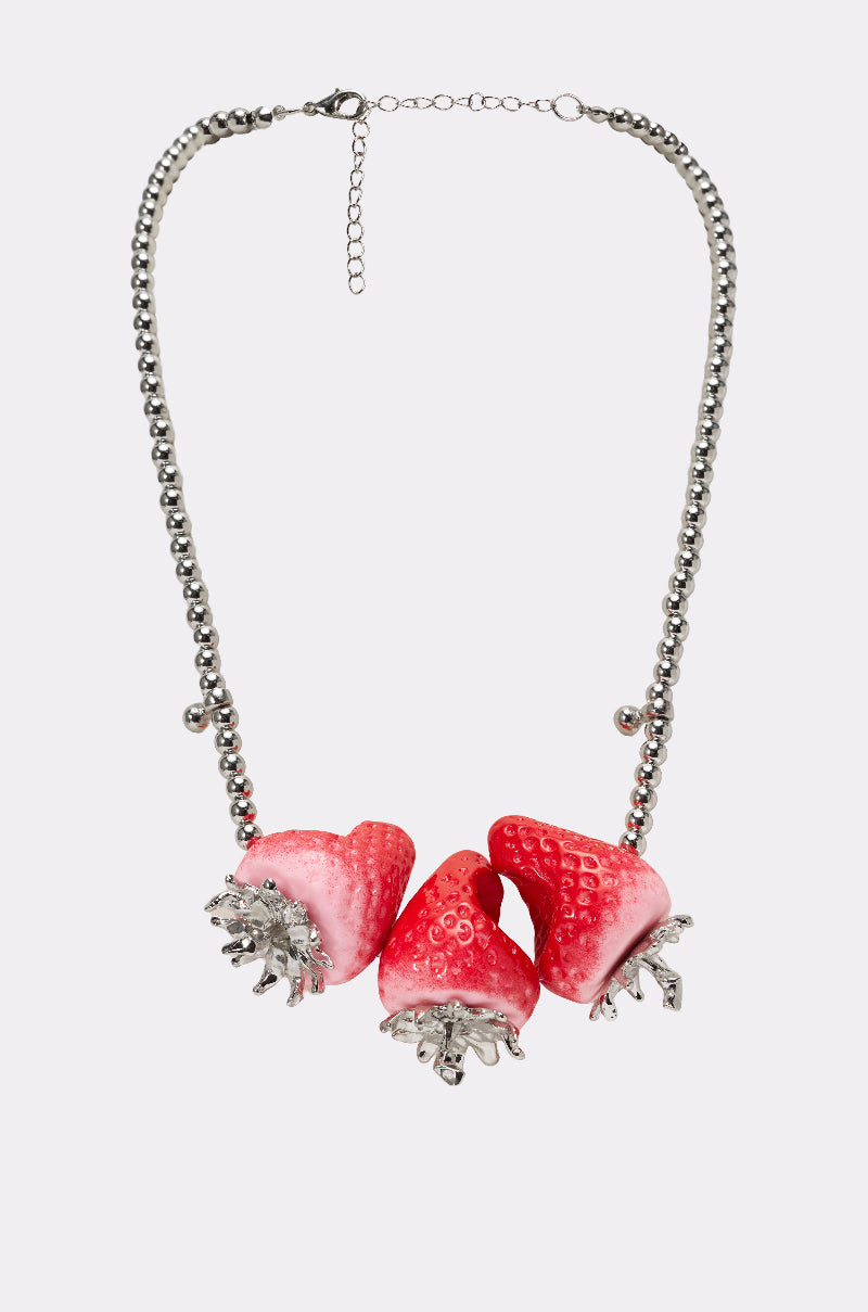 The BITE ME STRAWBERRY NECKLACE features a silver ball chain with three large, realistic red bitten strawberry charms accented by silver leaves, all displayed on a plain light background. 1