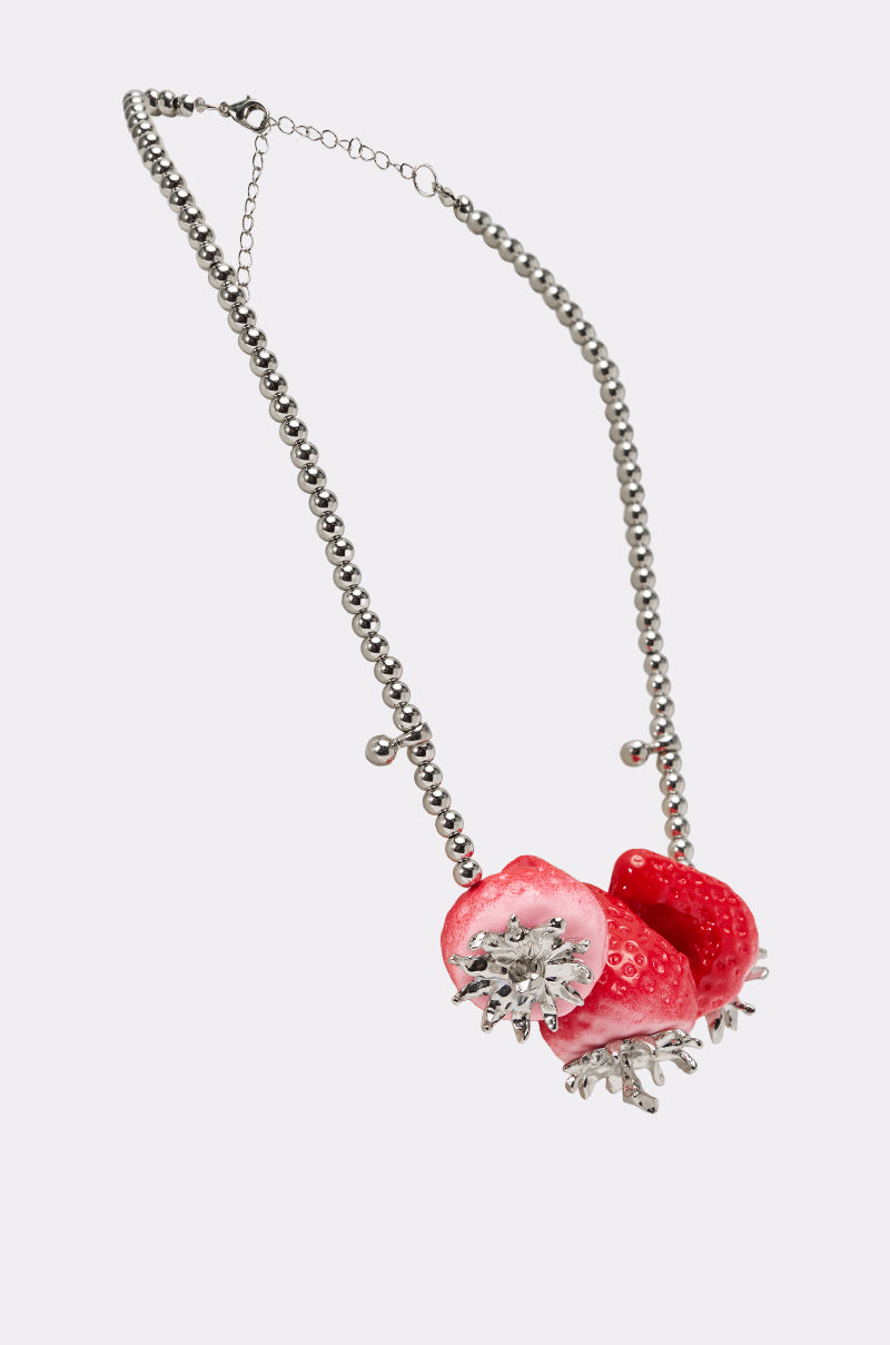The BITE ME STRAWBERRY NECKLACE is a silver ball chain with three realistic bitten strawberry charms featuring silver details, shown on a white background. 3