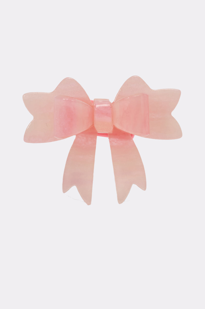 The KEKE PINK BOW RING is a pink, translucent hair clip with two loops and pointed tails, styled like a chic bow ring and shown against a white background. 3