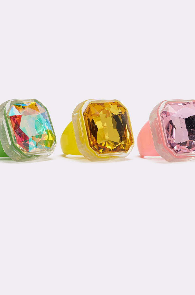 The GLINDA VIBES RING SET includes three vibrant acrylic statement rings with large square-cut gems in green, yellow, and pink, shown side by side on a white background. 4