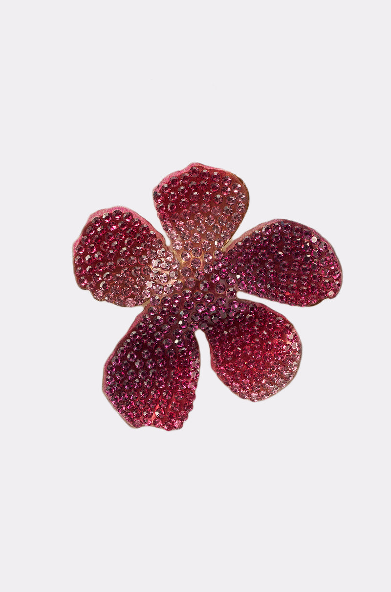 The WORTHY EARRING is a sparkling red and pink flower-shaped accessory with a crystal finish, encrusted with shiny rhinestones and displayed on a plain white background. 4