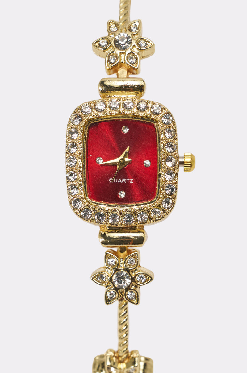 The ELEGANCE WATCH features a vintage-inspired gold-tone design with a red face, crystal hour markers, a rhinestone-encrusted square bezel, and gold flower accents on the band. "Quartz" is displayed on the watch face. 3