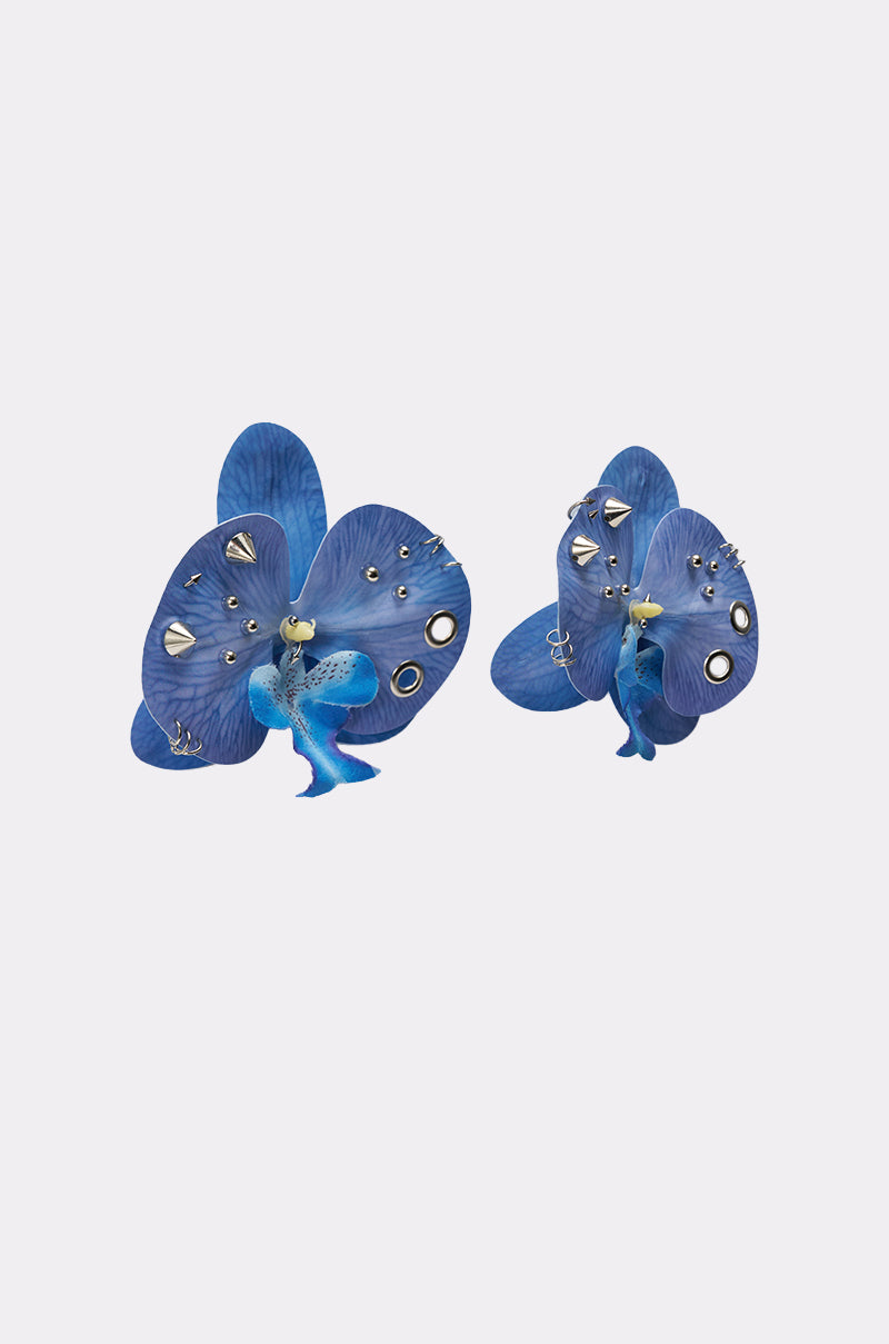 The EDGY VIBES EARRING features two butterflies with vibrant cobalt blue wings adorned with metallic studs, spikes, and rings, displayed against a plain white background. 3