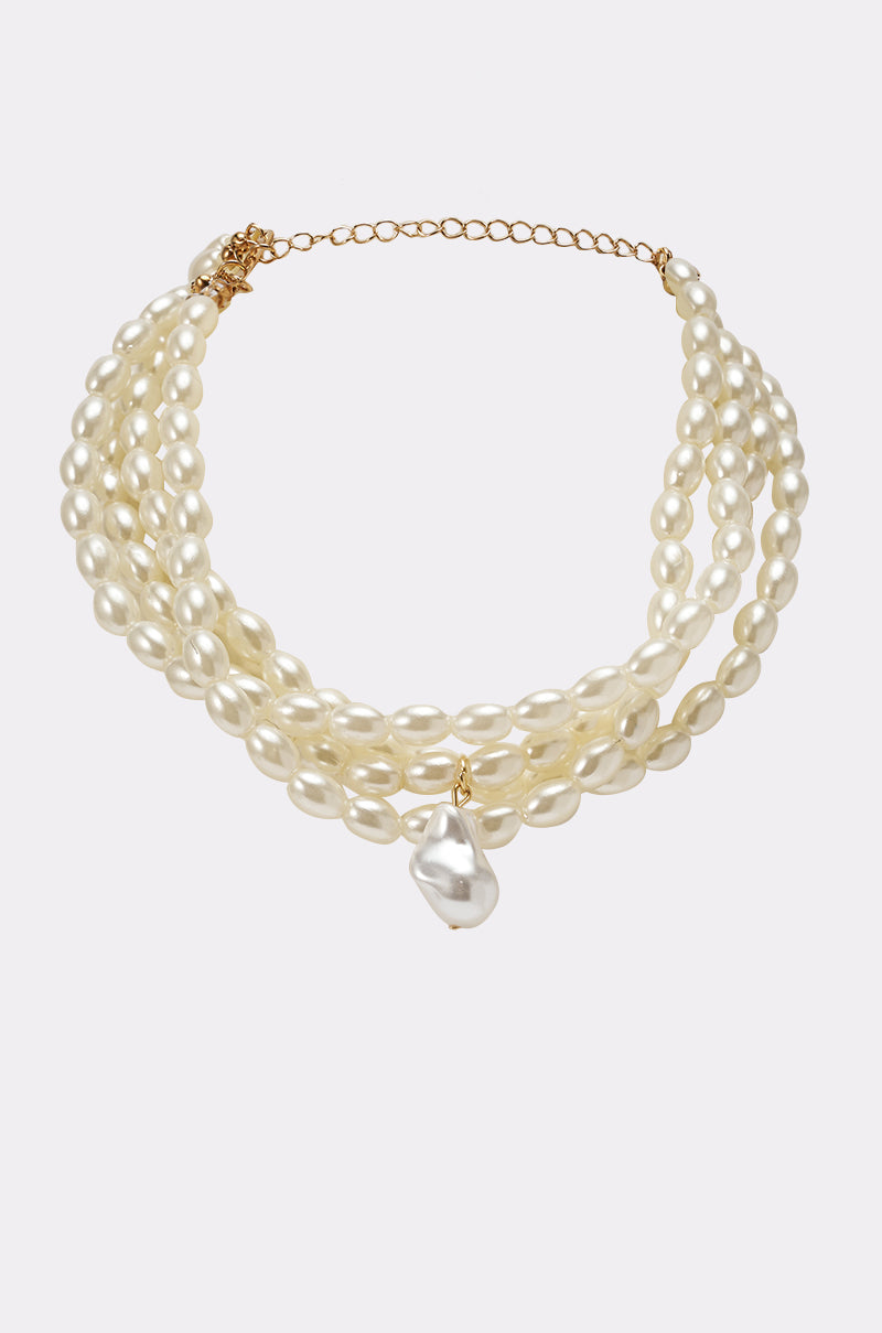 The IN THE OCEAN NECKLACE is a layered choker featuring faux pearls, a gold clasp, adjustable chain, and a bold baroque pearl pendant at the center. Its creamy white luster makes it a standout statement piece. 1