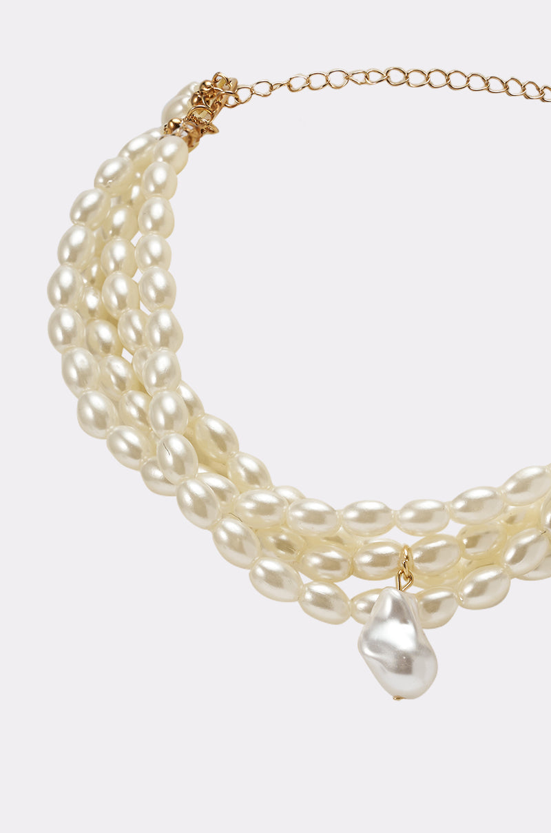 The IN THE OCEAN NECKLACE is a gold chain statement choker with three strands of oval faux pearls and a central large baroque teardrop pendant. 2
