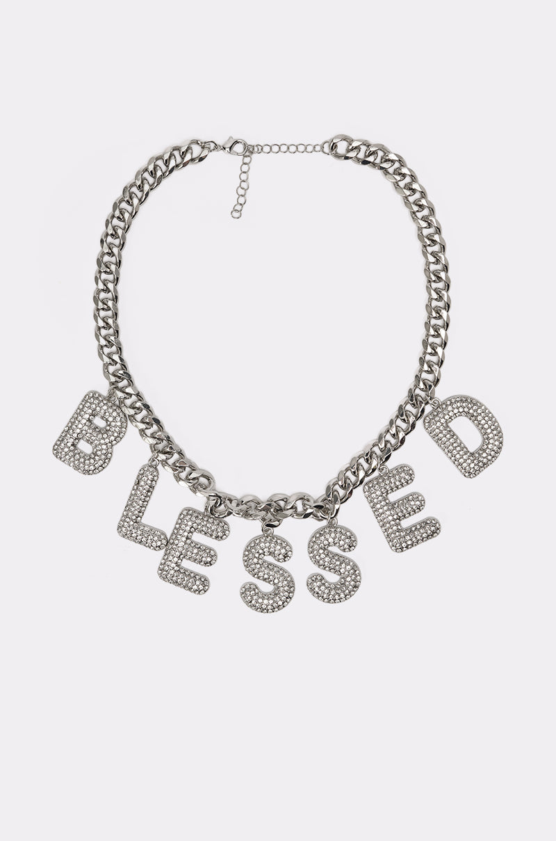 The BEYOND BLESSED NECKLACE is a bold, chunky silver pavé statement piece with large rhinestone-encrusted letters spelling "BLESSED"—perfect for any occasion. 3