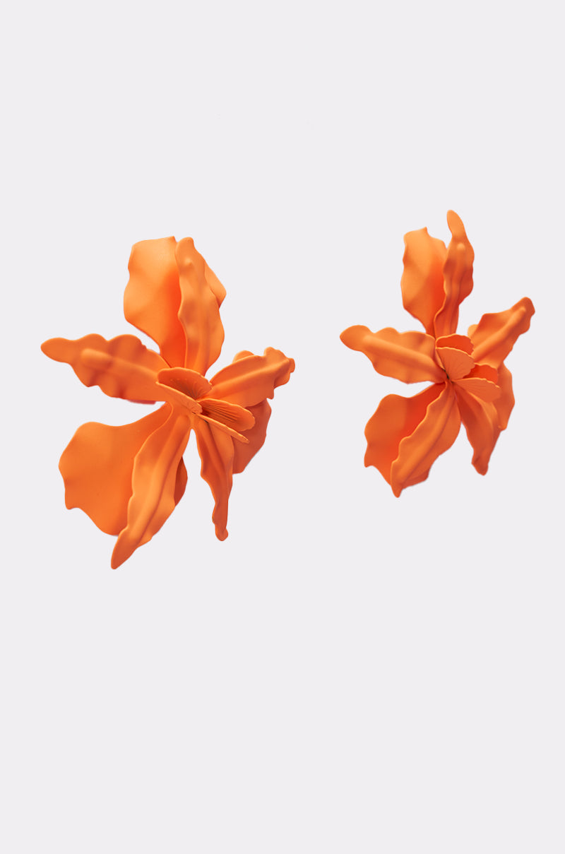 Two bold orange IDK U EARRING statement floral earrings with wavy petals are displayed against a plain white background. 4