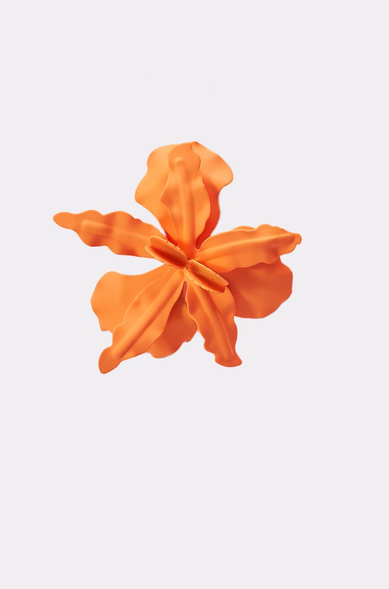 The IDK U EARRING is a bold, orange, flower-shaped accessory with five wavy-edged petals, displayed against a plain white background. 5