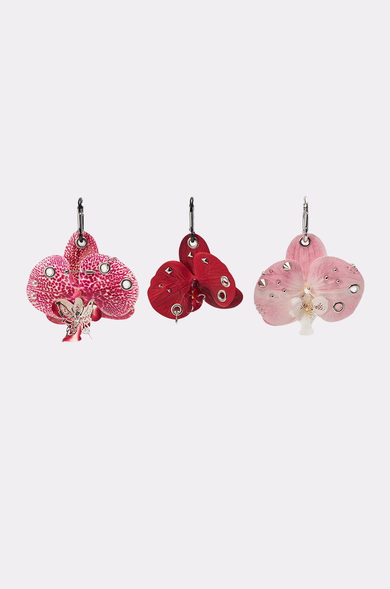 The PIERCED ORCHID FLOWER KEYCHAIN SET features three orchid keychains in pink, red, and light pink with sparkling rhinestones for a Y2K vibe, beautifully displayed on a plain white background. 2