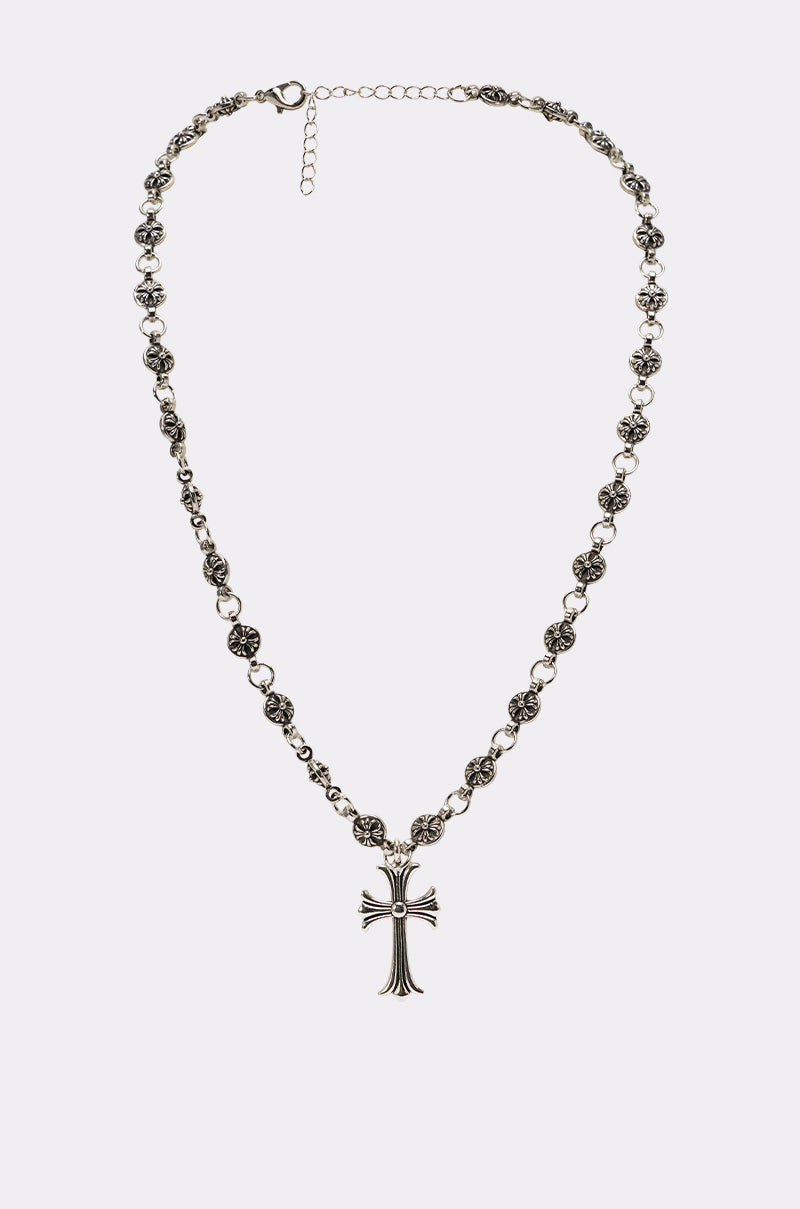 The WHATYA KNOW NECKLACE, featuring an ornate silver link chain with round beads and a detailed cross pendant, is displayed on a plain white background. 1