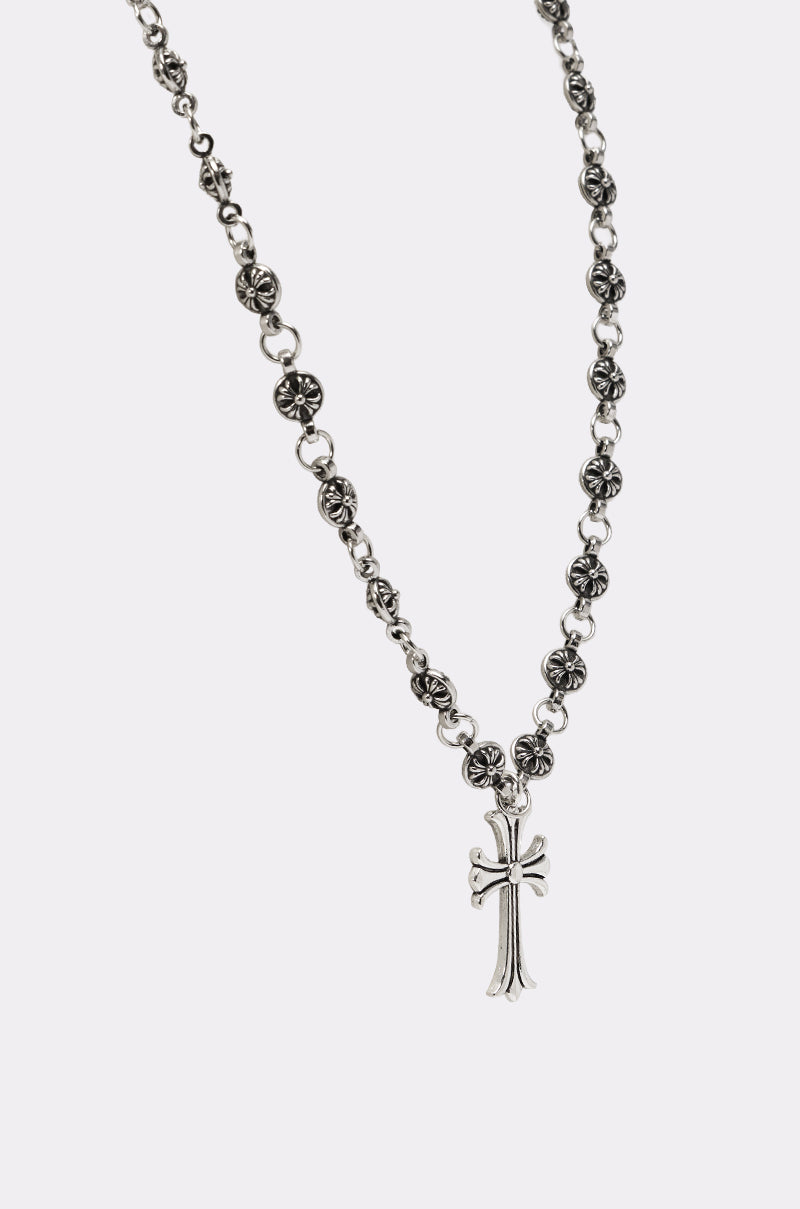 The WHATYA KNOW NECKLACE is a gothic silver cross necklace with ornate round floral links and a detailed cross pendant, shown on a plain white background. 4
