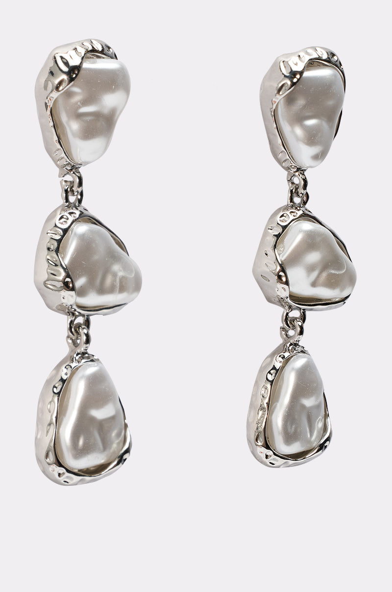 The SUE EARRING is a pair of silver drop earrings with three irregular, silver-toned segments, each set with a pearl-like center—a modern and elegant choice for evening wear. 4