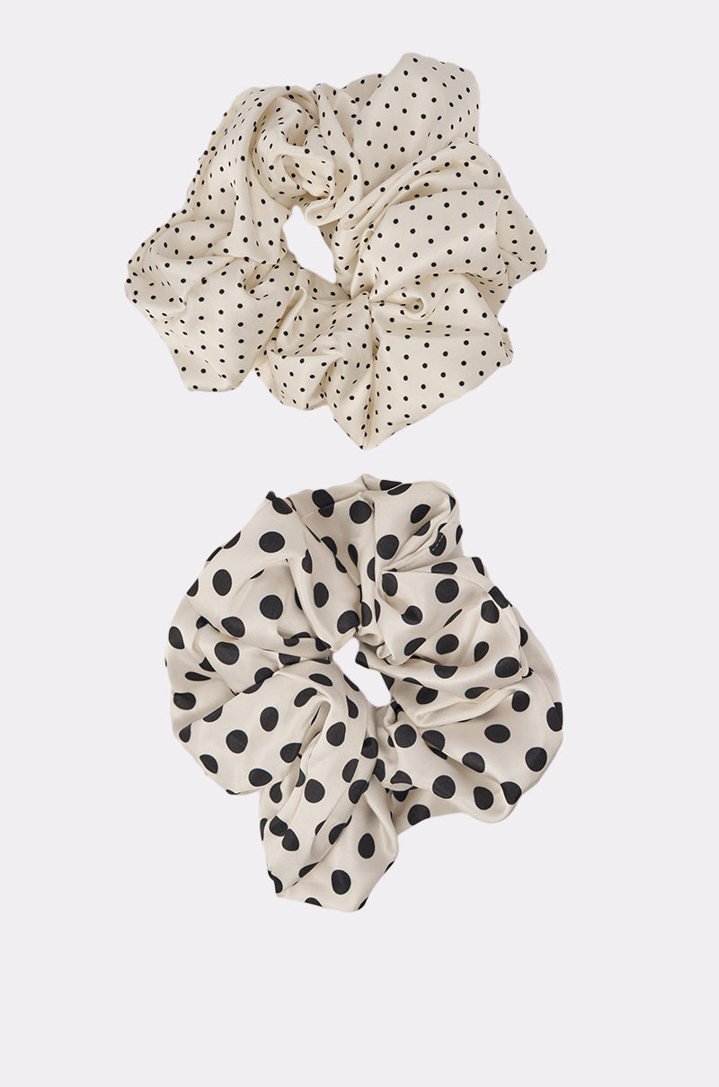 The POLKA DOT IT SCRUNCHIE SET includes two cream satin hair scrunchies with black polka dots—one with small dots, the other with oversized dots—displayed on a plain white background. 6