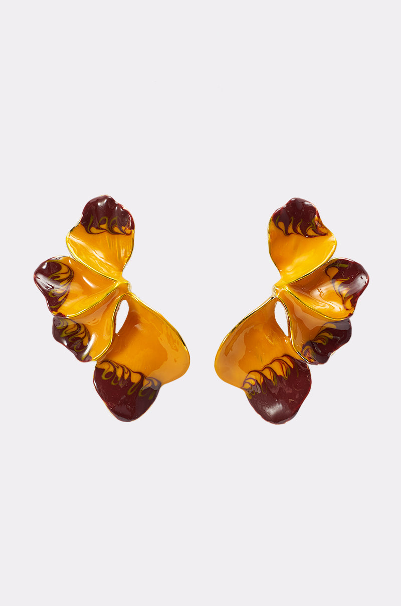 FLOWER POWER EARRING: Abstract, butterfly-shaped statement drop earrings with yellow and dark red marbled enamel, cutout details, and a glossy finish are displayed on a plain light background. 1