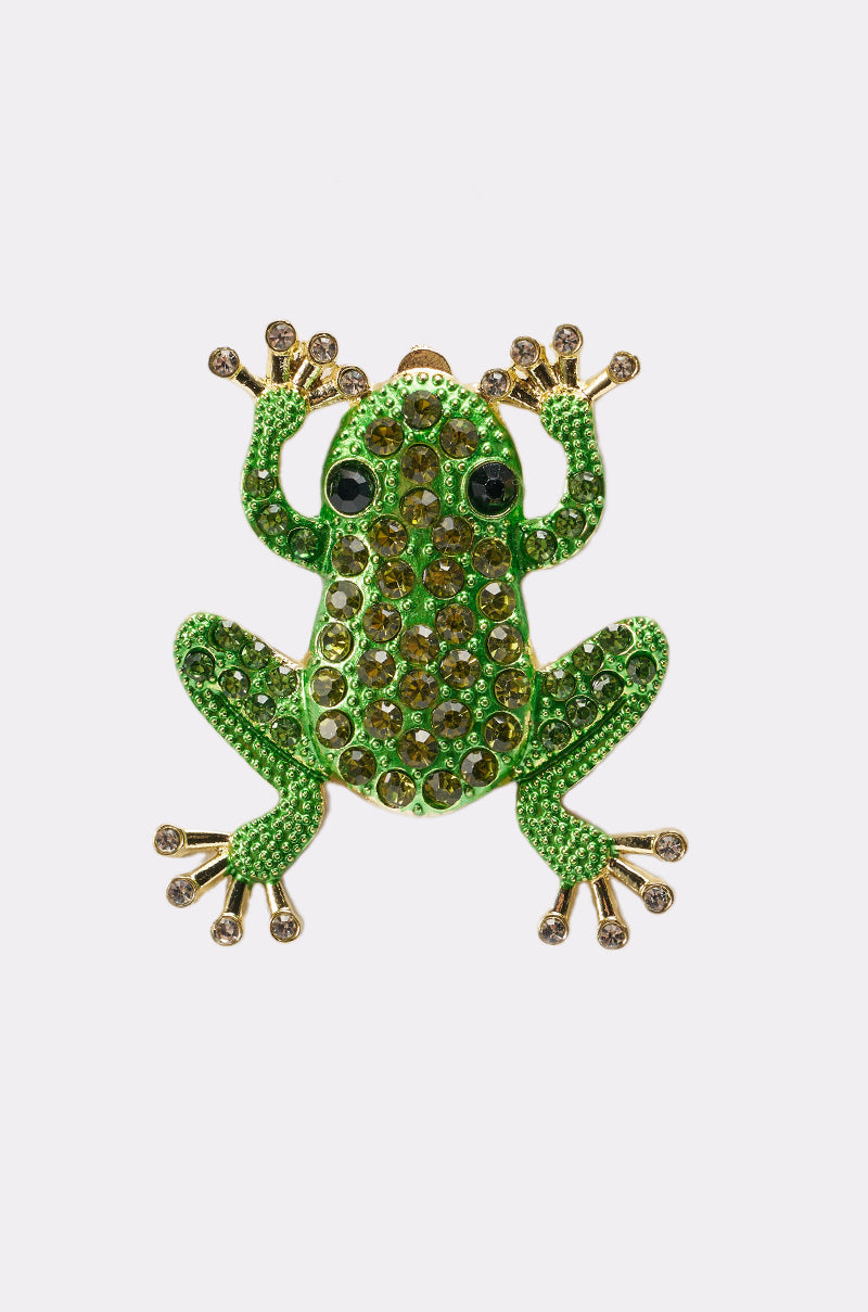 The HERE I COME EARRING features sparkling green and yellow gemstones, gold-accented feet, and large black eyes in a jeweled frog design—displayed against a plain white background. 5