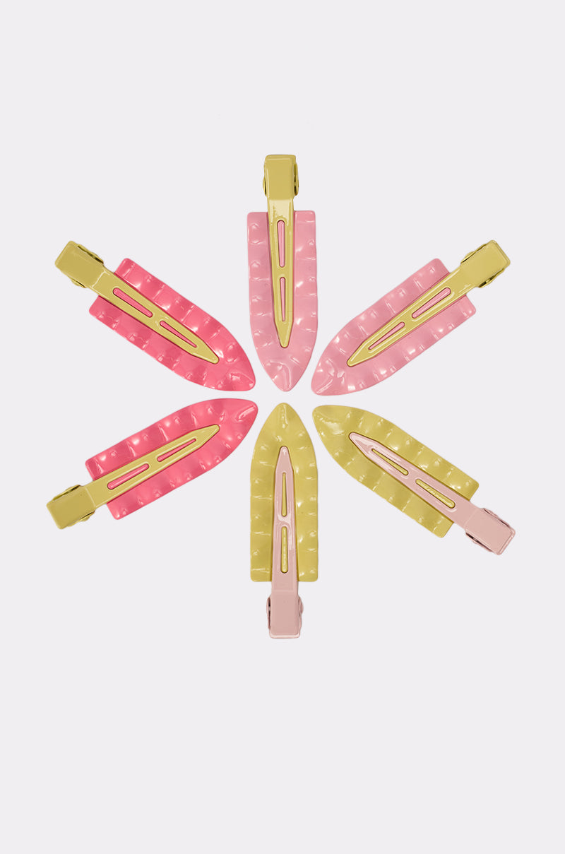 Six colorful enamel PROUD OF U FLAT CLIP SET hair clips—pink, yellow, and peach—form a flower pattern on white with pointed ends outward. These snap clips add a retro vibe to any look. 1