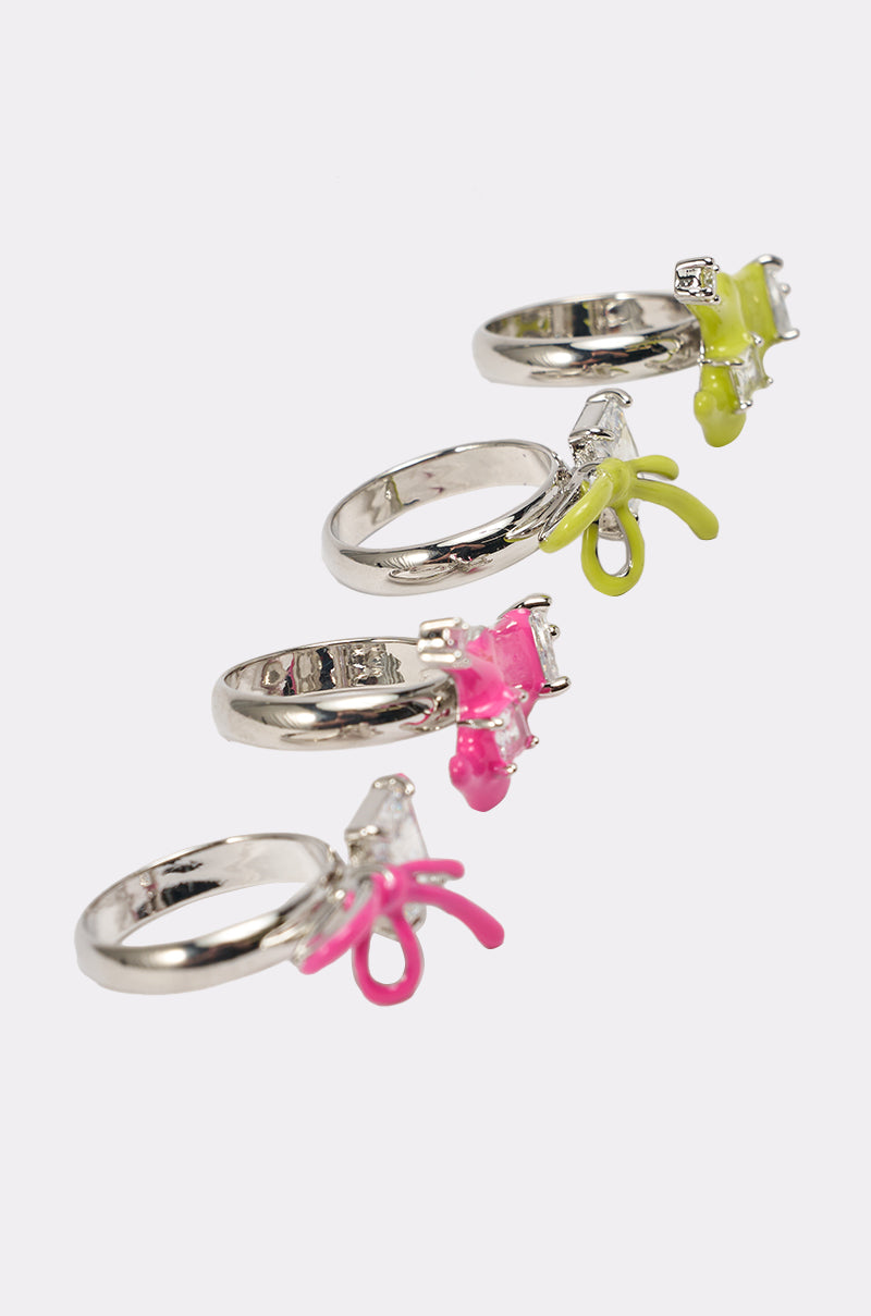 Four silver rings from the TOO TRENDY RING SET are displayed diagonally on a white background, each with neon yellow or pink abstract accents and a small clear gemstone—the ideal Y2K-inspired statement jewelry for bold style lovers. 4