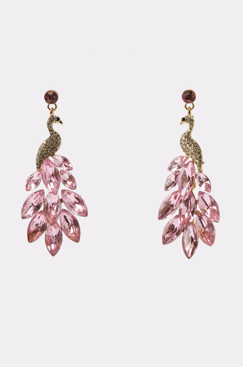 The IN MIAMI EARRING features peacock drop earrings crafted from gold-colored metal with pink gemstone feathers, shown against a plain white background. 1