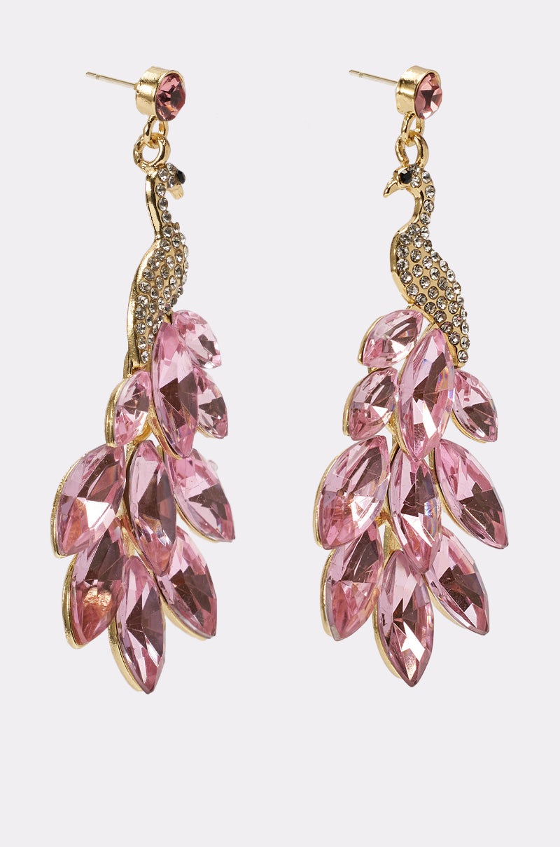 The IN MIAMI EARRING features gold-tone peacock drop earrings with crystal-studded bodies and bold tails adorned with large pink marquise-shaped gemstones. 2