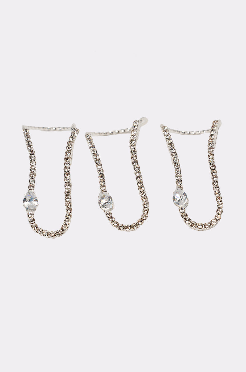 The WAVEY RING SET features three delicate silver rings with small, clear rhinestone embellishments, each showcasing a single gemstone set along the band. Displayed against a plain white background. 1