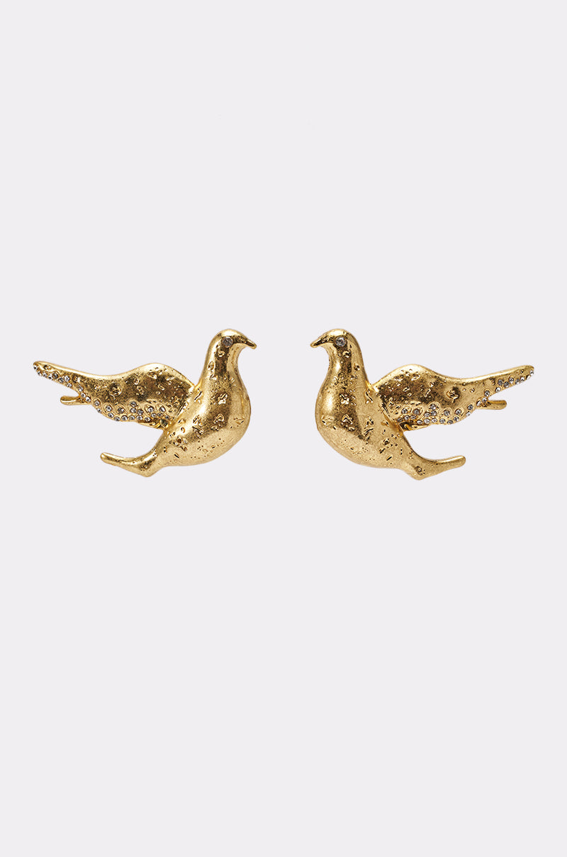 The SPREAD YOUR WINGS EARRING is a pair of gold-tone bird stud earrings featuring textured wings and bodies, designed to face each other. Set against a plain white background. 1