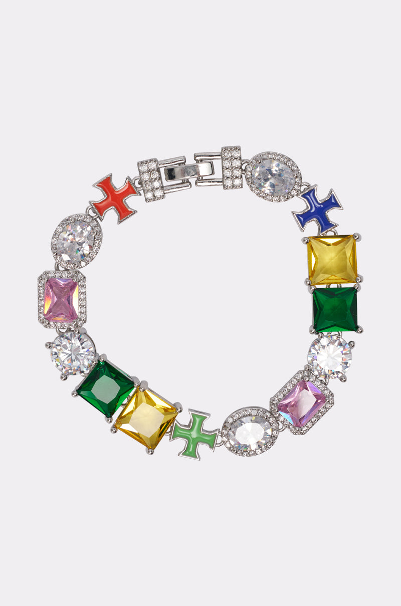 The LETS GET IT CZ BRACELET features large, colorful gemstones in various shapes with sparkling clear stones and multicolored cross motifs set on a silver band, shown against a plain background. 0