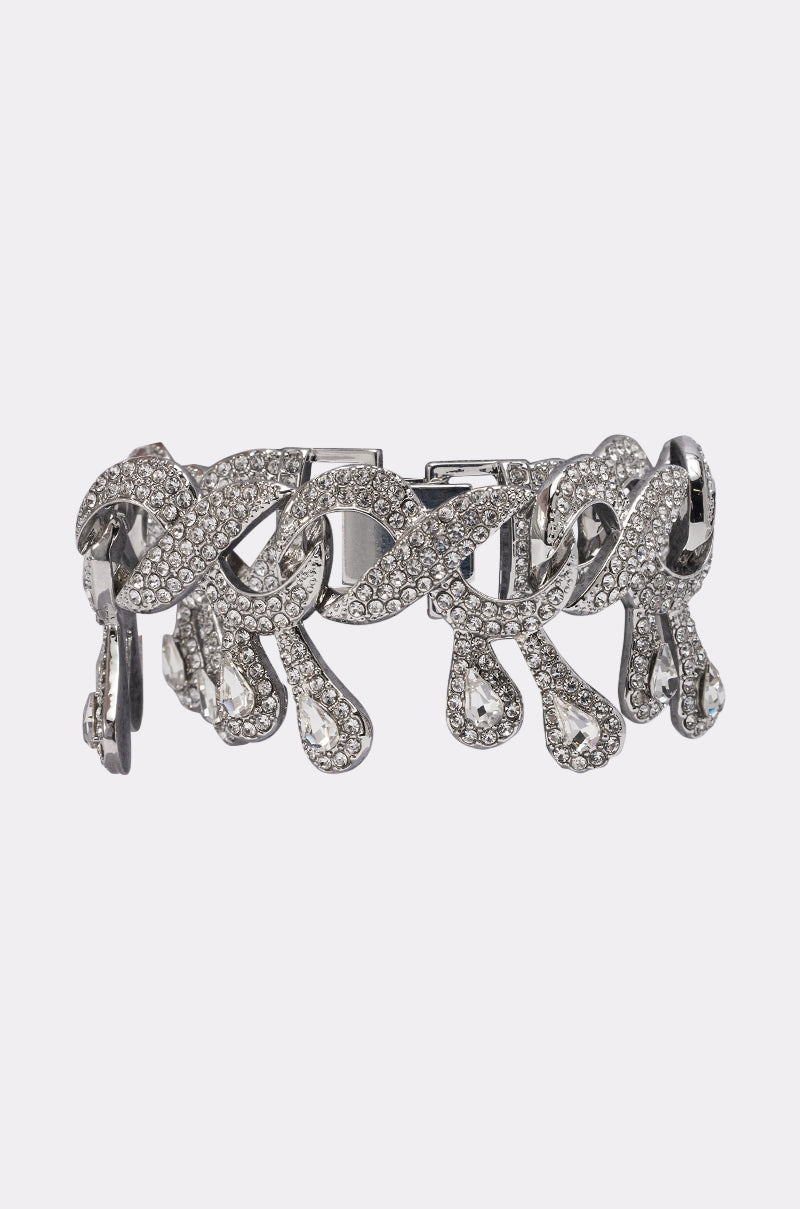 The DRIPPIN BRACELET is a silver-tone piece with sparkling clear rhinestones, an intricate swirl design, and teardrop dangles—an elegant crystal accent perfect for any occasion. 0