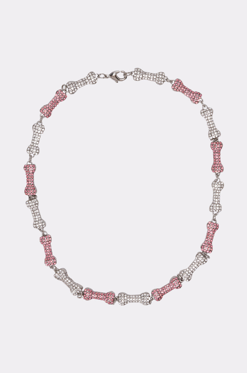The GIVE A DOG A BONE NECKLACE features alternating pink and silver rhinestone bone-shaped links with clear and pink gemstones, evenly spaced and connected by a clasp for a playful statement accessory. 0