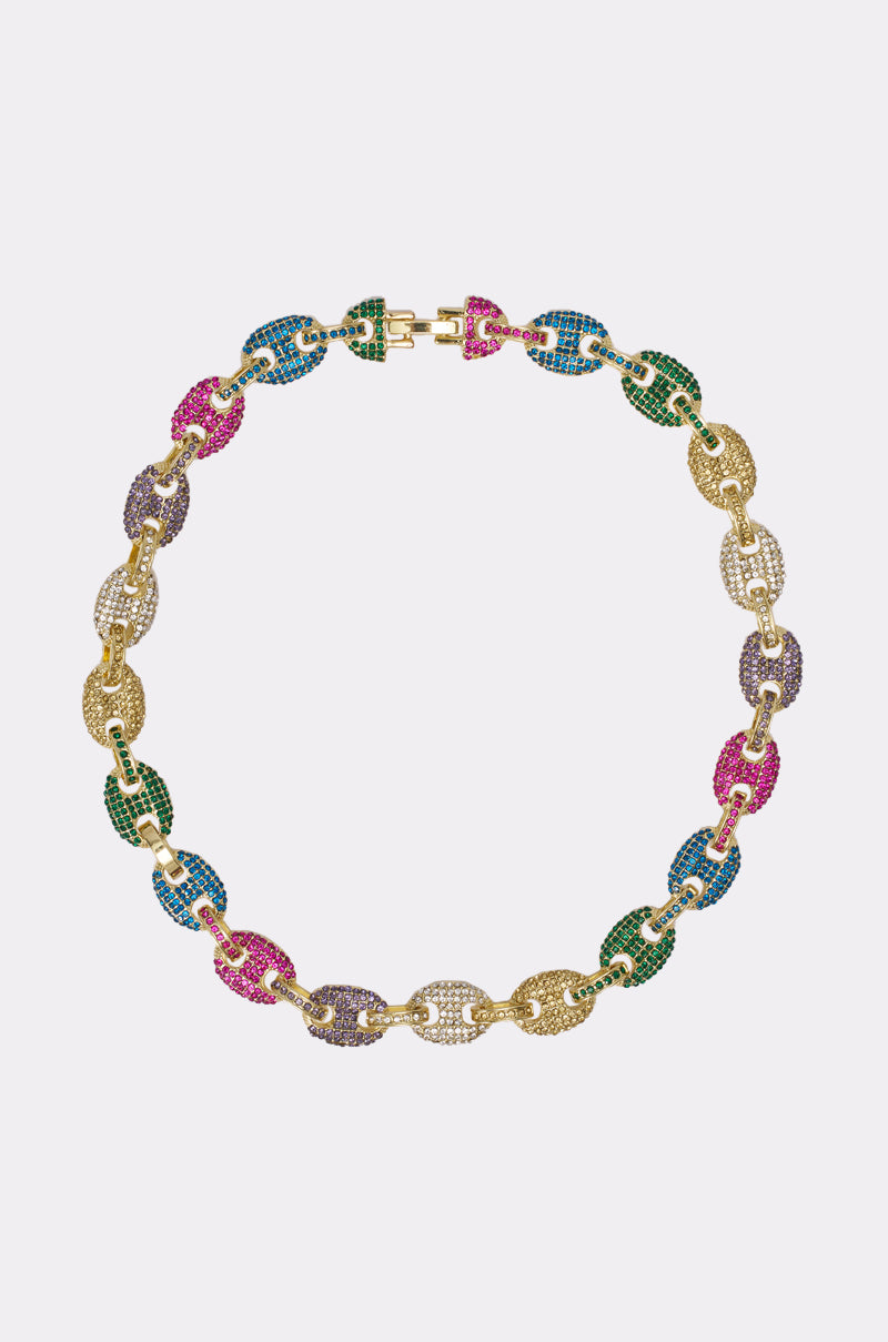 The SUMMERTIME FINE LUXE NECKLACE is a multicolor chain necklace with interlocking links encrusted with green, blue, purple, and pink gemstones and bold rhinestone details, shown against a plain white background.