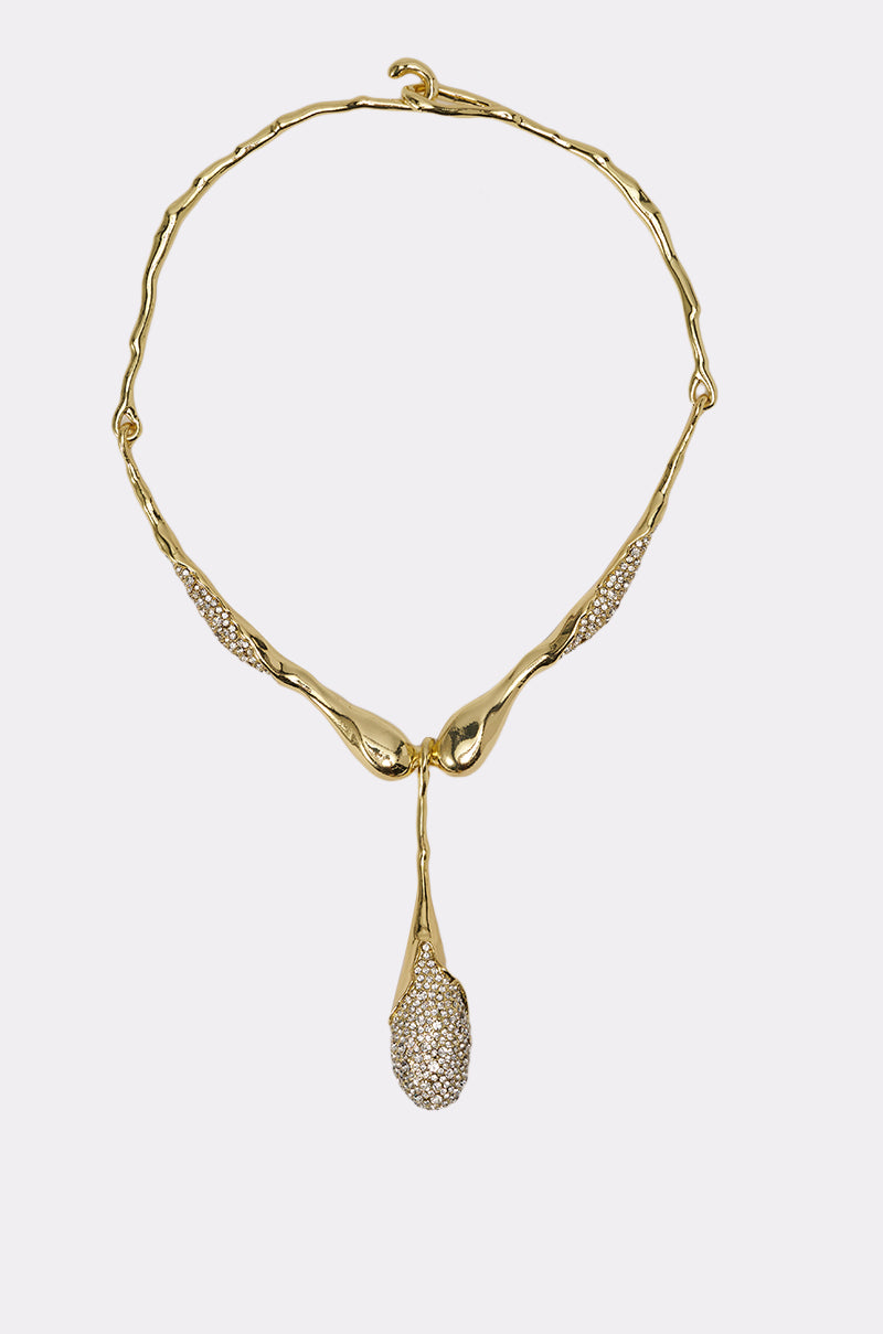 The IN YOUR DREAMS NECKLACE is a gold-tone collar necklace with a wavy, organic design, sparkling textured sections, and a drop-shaped pendant encrusted with clear crystals and subtle rhinestone accents for artistic flair. 0