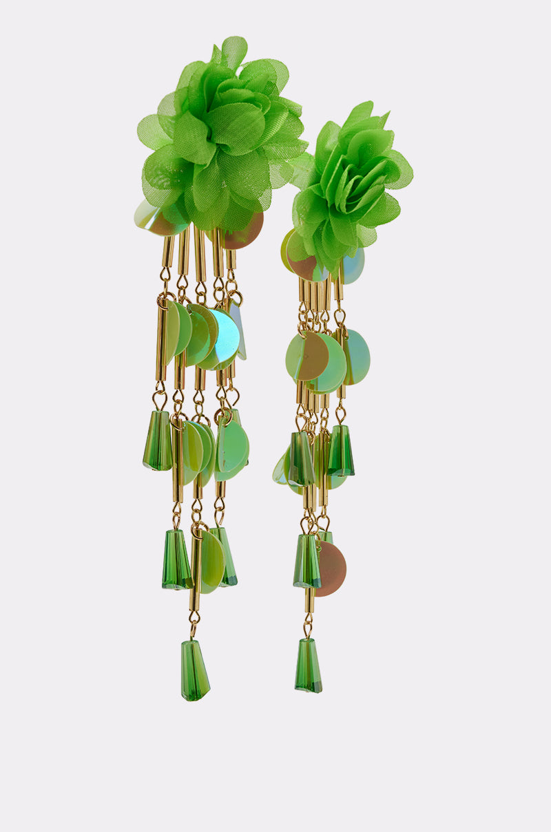 The NO ENVY EARRING features bold green fabric flowers atop gold chains with beaded fringe, shiny green discs, and cone-shaped beads in a decorative statement design against a plain, light-colored background. 3