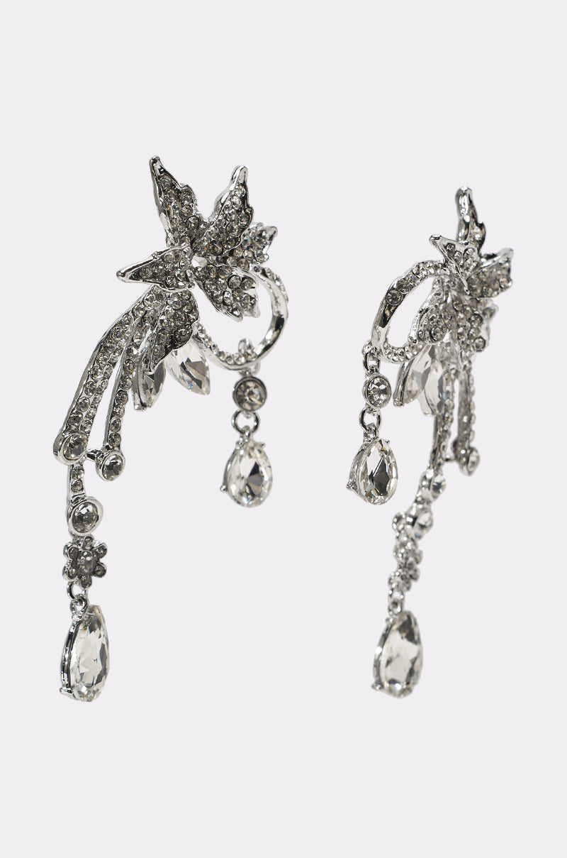 Add an elegant touch with the TRIANA EARRING—a pair of ornate silver drop earrings featuring sparkling crystals, dangling teardrop gems, and floral vine-like designs. Perfect as bridal earrings for your special day. 2