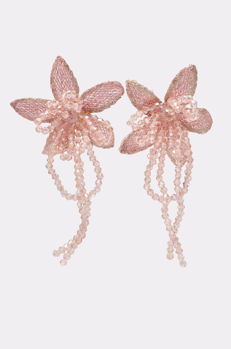 The I WANT TO TWIRL EARRING features pink, flower-shaped beaded earrings with dangling strands, orchid-inspired petals—a standout choice for weddings—shown on a plain white background. 1