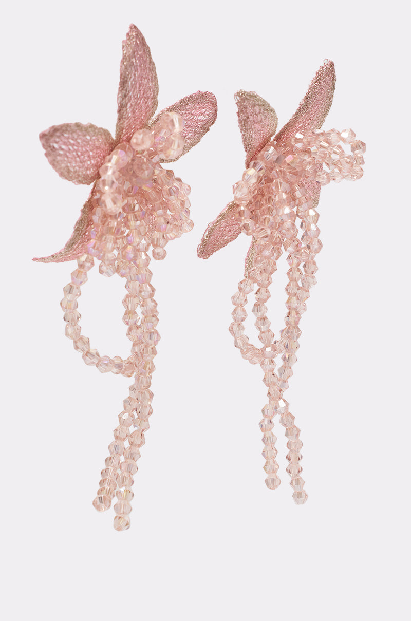 The I WANT TO TWIRL EARRING features pink floral beaded drop earrings with petal-inspired elements and cascading translucent strands, perfect as statement jewelry. Shown on a plain white background. 2