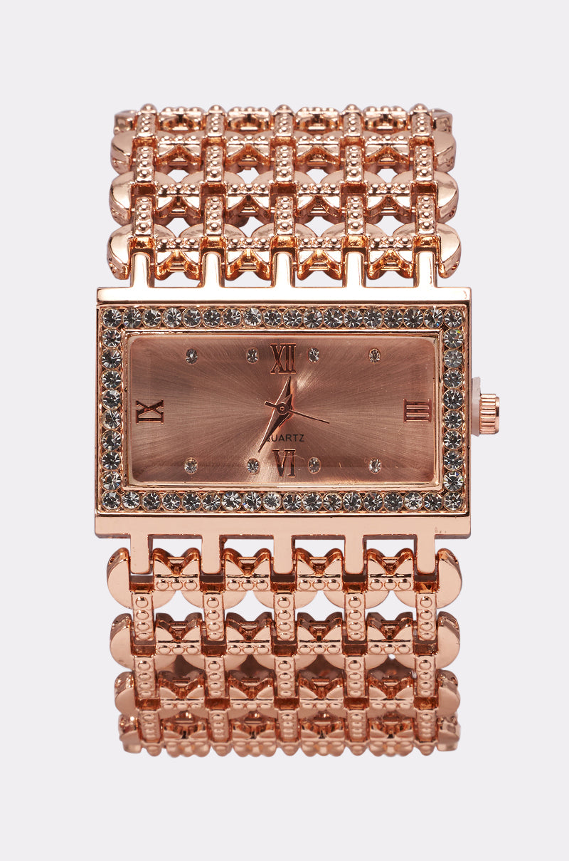 The FEELIN ROSEY WATCH features a rectangular rose gold case, crystal-studded bezel, Roman numeral dial, and a wide textured chain band, shown on a plain white background.