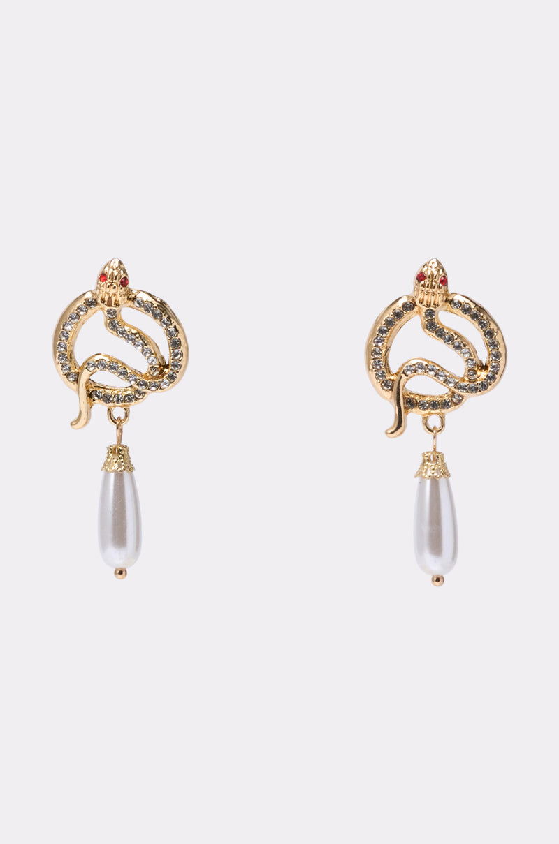 The UR A SNAKE EARRING features gold snake-shaped earrings with rhinestone details, red accents on the heads, and a teardrop pearl drop, displayed against a light background. 0