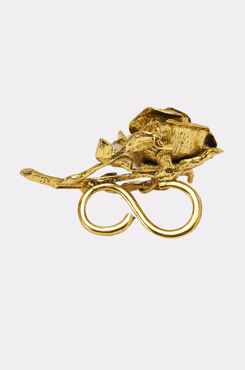 The IN BLOOM COCKTAIL RING features a gold floral design with detailed petals and leaves above an infinity symbol, all crafted in a shiny metallic finish. 2